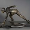 Bronze sculpture of a speed skater in mid turn