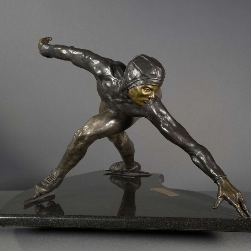 Bronze sculpture of a speed skater in mid turn