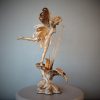 Bronze sculpture of a fairy with butterfly wings on top of a flower - left side