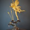 Bronze sculpture of a fairy covered in gold leaf with butterfly wings on top of a flower - right side