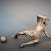 Bronze sculpture of a woman soccer player slide tackling the ball - front view